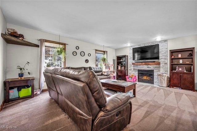 carpeted living area with baseboards and a fireplace