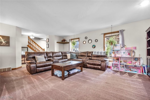 carpeted living room featuring stairway, baseboards, and visible vents