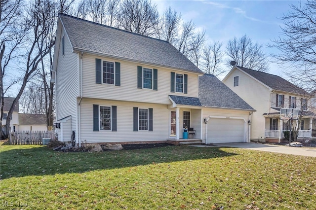 colonial house featuring driveway, a front lawn, a garage, and a shingled roof