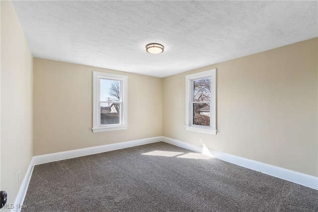 unfurnished room with plenty of natural light, baseboards, and carpet floors