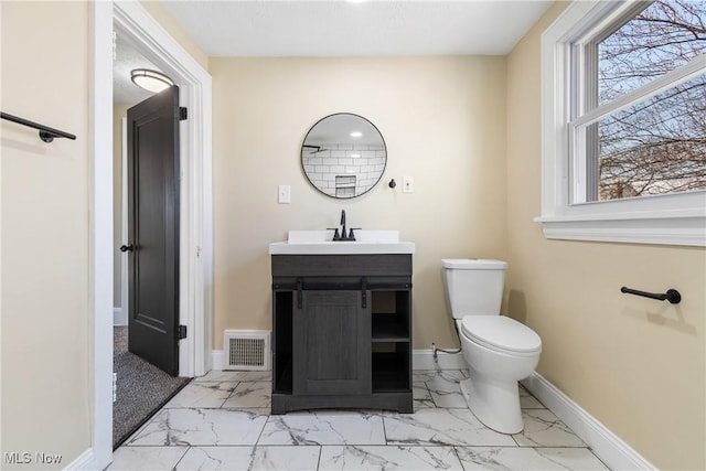 half bathroom with visible vents, toilet, marble finish floor, baseboards, and vanity