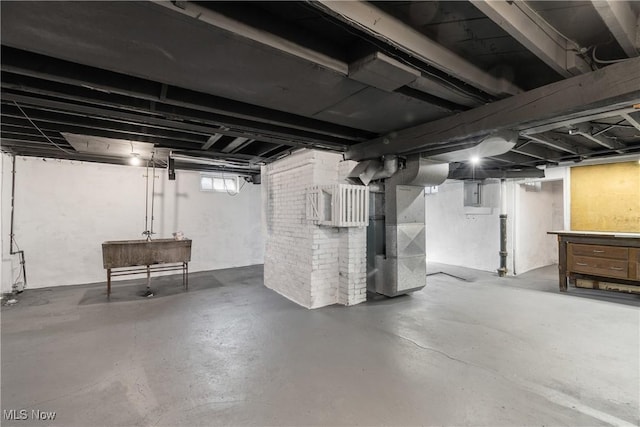 basement featuring electric panel and heating unit