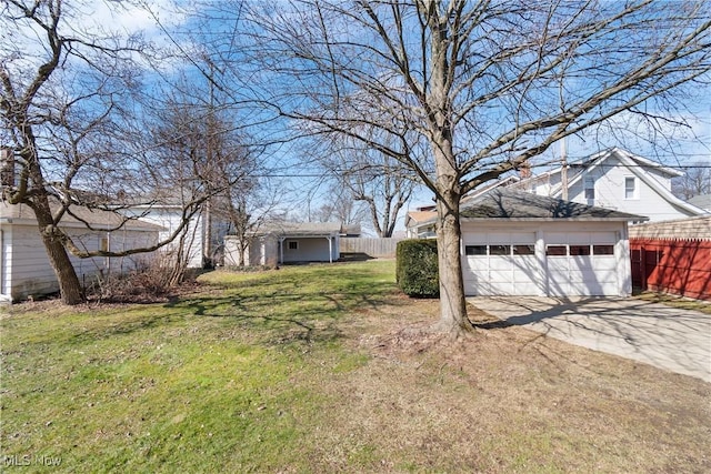 view of yard featuring an outdoor structure, a garage, and fence