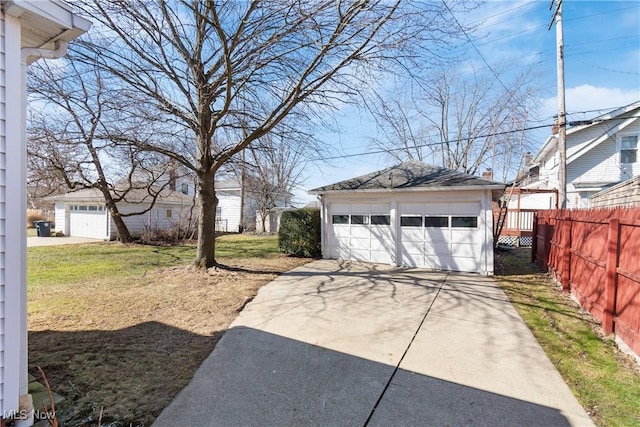 detached garage featuring fence