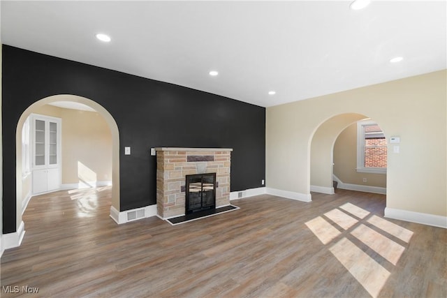 unfurnished living room featuring wood finished floors, a fireplace, and baseboards