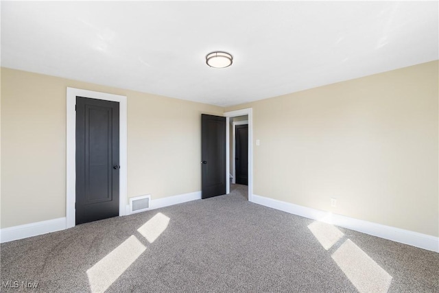 unfurnished bedroom featuring visible vents, baseboards, and carpet