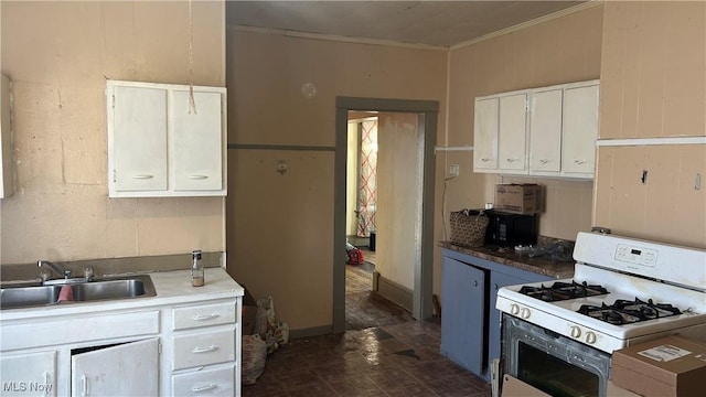 kitchen featuring a sink, white cabinets, white gas range oven, and ornamental molding