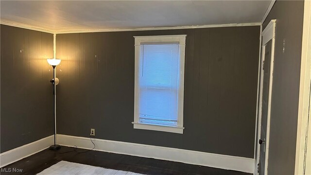 spare room featuring baseboards and crown molding