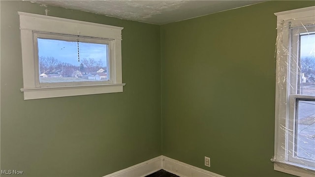 spare room with a healthy amount of sunlight and baseboards