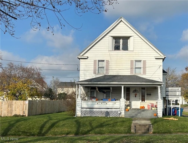 view of front facade featuring a front yard, fence, and covered porch