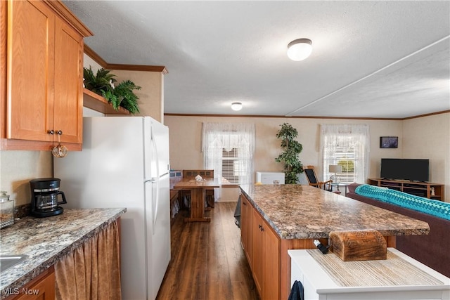 kitchen featuring ornamental molding, a kitchen island, freestanding refrigerator, and dark wood-style flooring