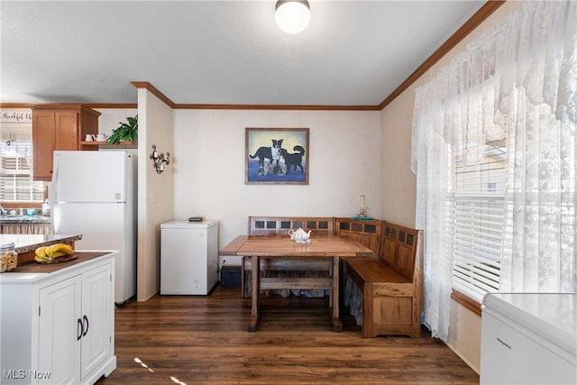 dining space with breakfast area, crown molding, and wood finished floors