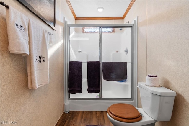 bathroom featuring wood finished floors, a shower with door, and ornamental molding