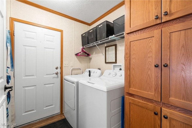 washroom featuring cabinet space, independent washer and dryer, a textured ceiling, and crown molding