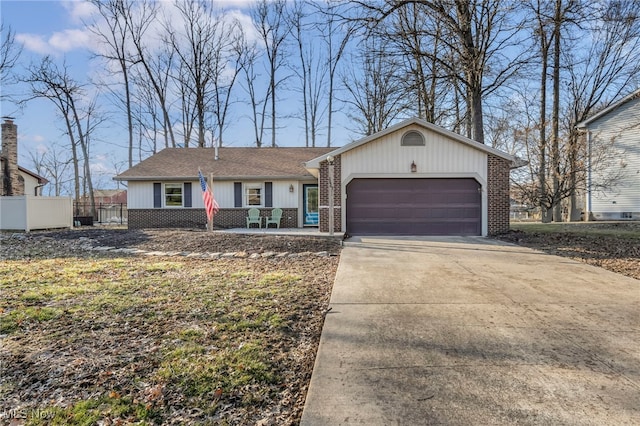 view of front of property featuring concrete driveway, a garage, fence, and brick siding