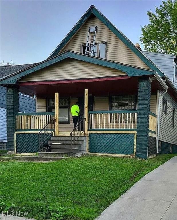 bungalow-style house with covered porch and a front lawn