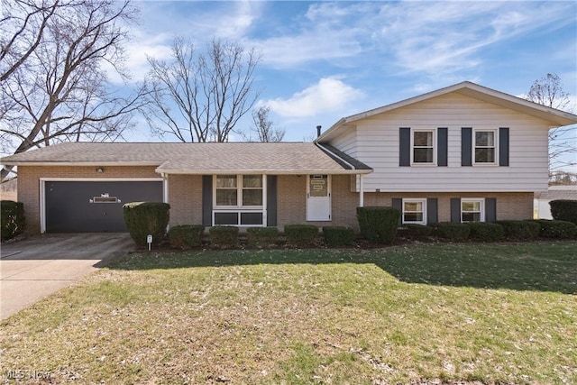 tri-level home with brick siding, a garage, a front yard, and driveway