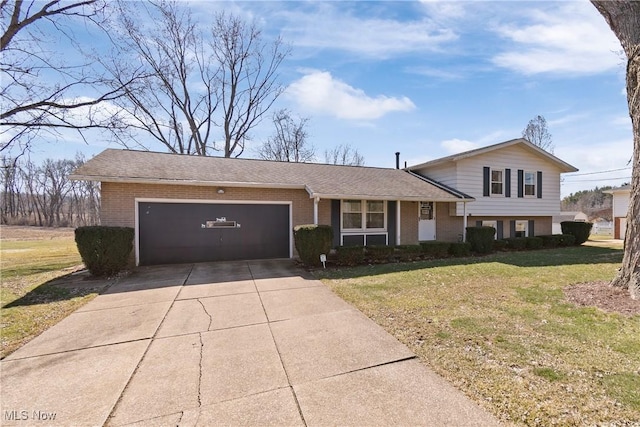 tri-level home featuring concrete driveway, an attached garage, brick siding, and a front yard