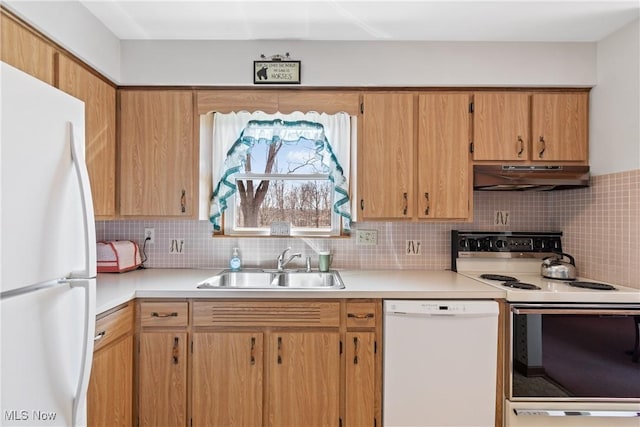 kitchen featuring under cabinet range hood, white appliances, light countertops, and a sink