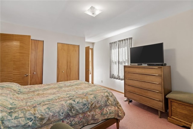 bedroom with carpet flooring, baseboards, and multiple closets