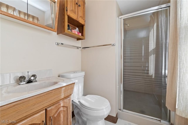 bathroom with vanity, toilet, and a stall shower