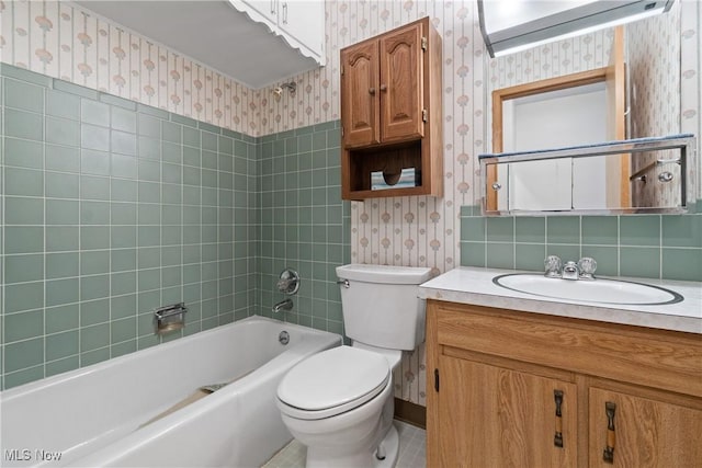 bathroom with tub / shower combination, toilet, vanity, and wallpapered walls