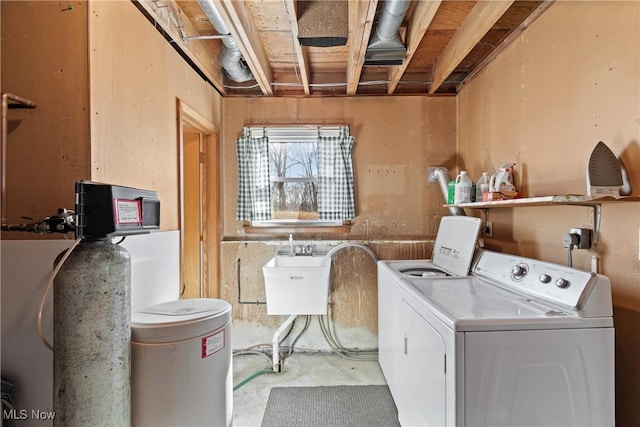 washroom with washing machine and clothes dryer, laundry area, and a sink