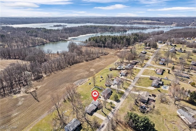 birds eye view of property featuring a forest view and a water view