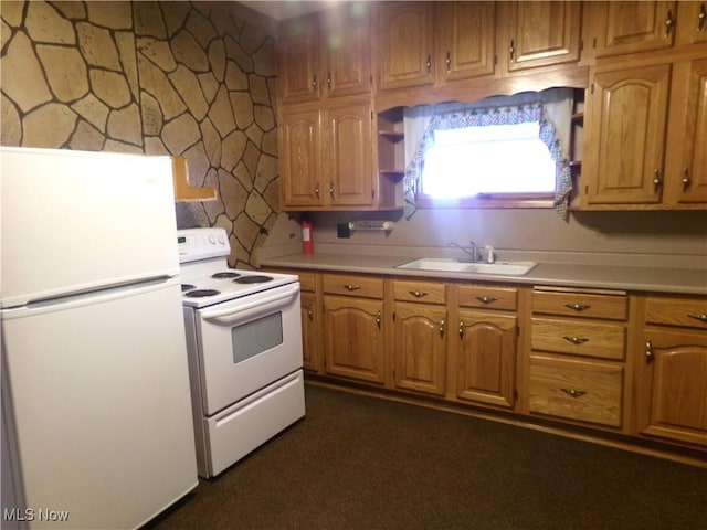 kitchen featuring white appliances, brown cabinetry, light countertops, and a sink