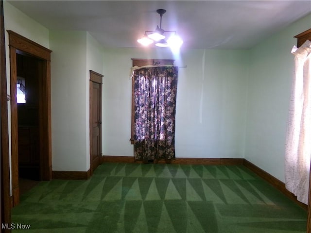 unfurnished room featuring an inviting chandelier, carpet flooring, and baseboards