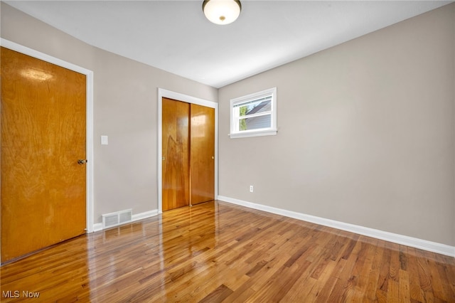 unfurnished room with visible vents, baseboards, and wood finished floors