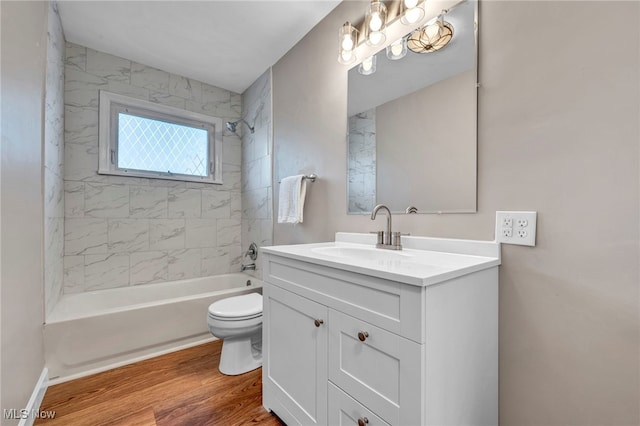 full bath with toilet, vanity,  shower combination, and wood finished floors