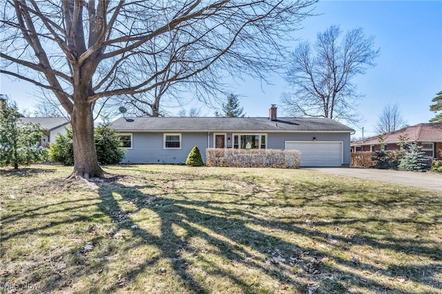 single story home with a chimney, driveway, a front yard, and a garage