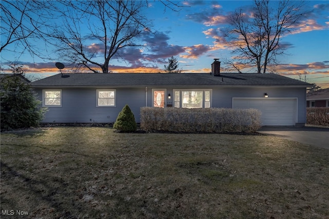 single story home with a lawn, an attached garage, a chimney, and concrete driveway