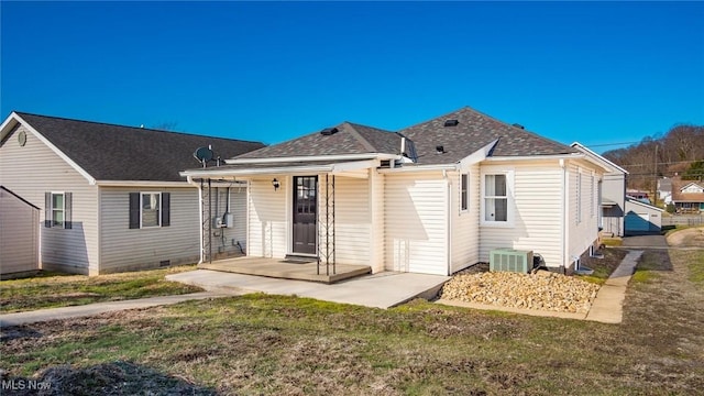 rear view of house featuring crawl space, central air condition unit, a shingled roof, and a yard