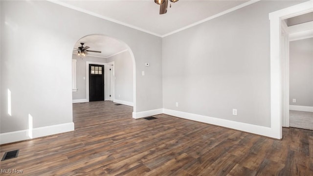 spare room with wood finished floors, visible vents, arched walkways, ceiling fan, and crown molding