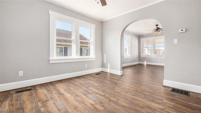 unfurnished room with visible vents, arched walkways, ceiling fan, and ornamental molding