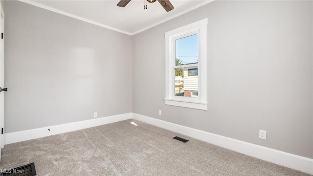 carpeted empty room featuring visible vents, a ceiling fan, baseboards, and ornamental molding