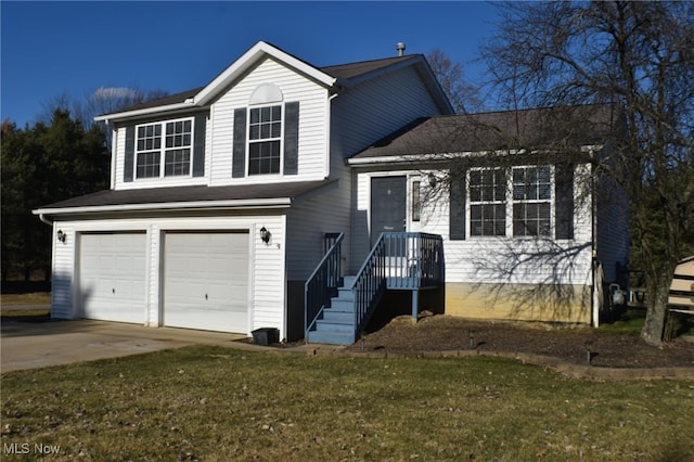 split level home with a front yard, an attached garage, and driveway