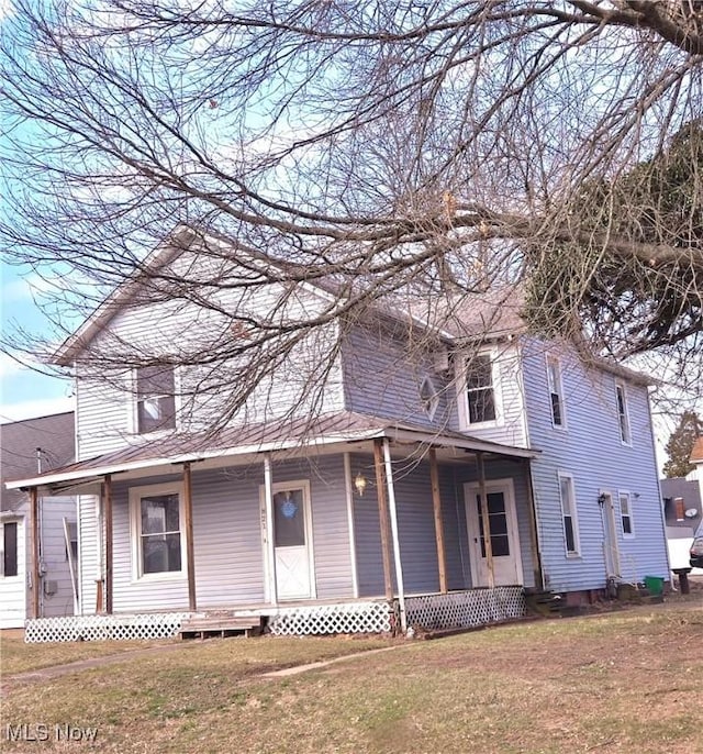 view of front of property featuring entry steps, a front yard, and covered porch