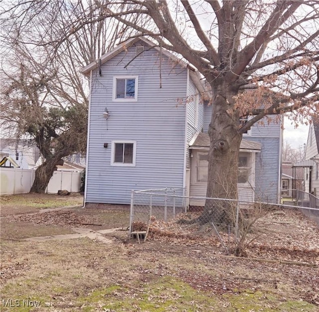 rear view of property featuring fence