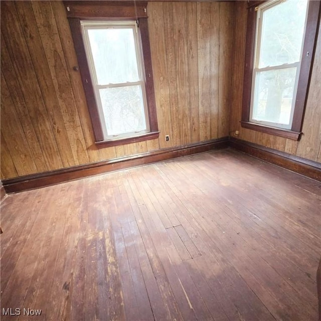 spare room featuring a wealth of natural light, baseboards, and hardwood / wood-style floors