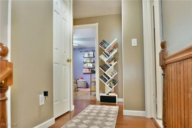 hallway with baseboards and wood finished floors