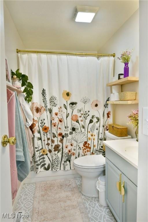 full bathroom featuring tile patterned floors, a shower with shower curtain, toilet, and vanity