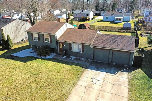 split level home with a residential view, driveway, a front lawn, and fence