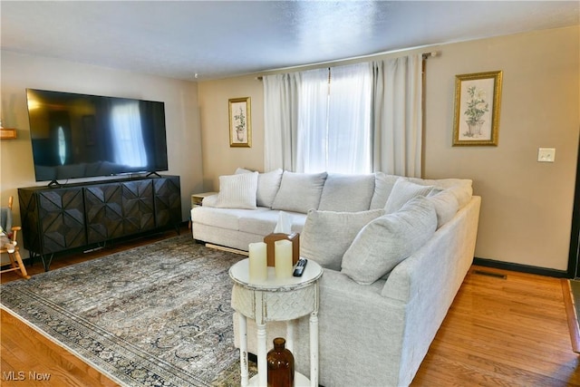 living room with wood finished floors and visible vents