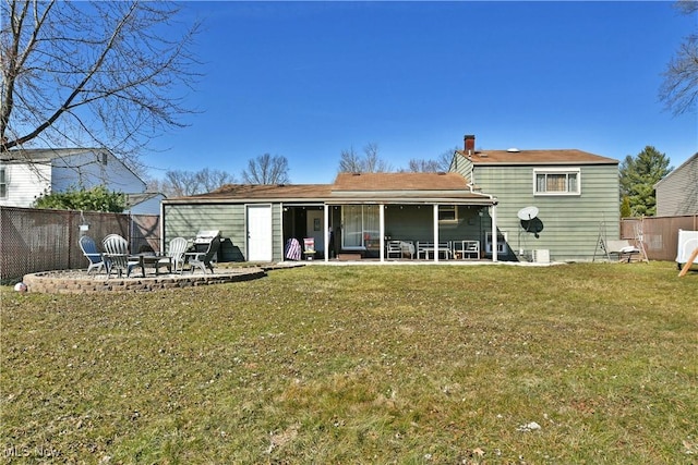 back of house with a yard, a patio area, fence, and an outdoor fire pit