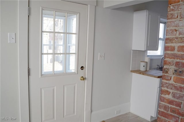 1341 Beach Ave, Lakewood, OH 44107 - doorway to outside featuring a wealth of natural light and brick wall