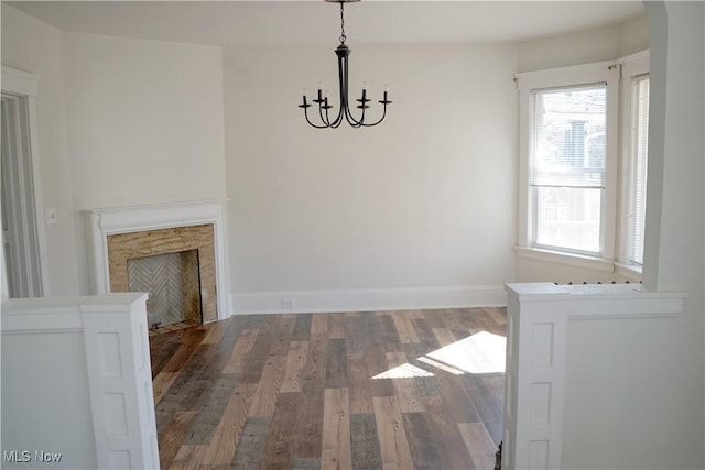 1341 Beach Ave, Lakewood, OH 44107 - unfurnished dining area featuring a chandelier, a fireplace, baseboards, and wood finished floors