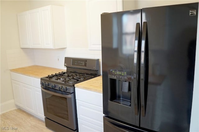 1341 Beach Ave, Lakewood, OH 44107 - kitchen featuring stainless steel gas stove, black fridge with ice dispenser, white cabinetry, butcher block counters, and decorative backsplash